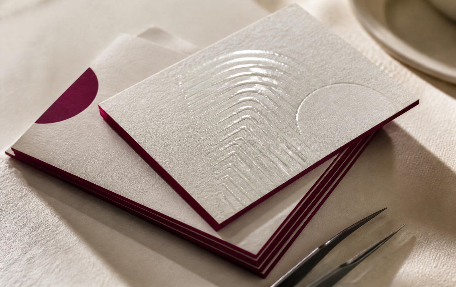 Stack of thick business cards with painted magenta edges and raised spot UV